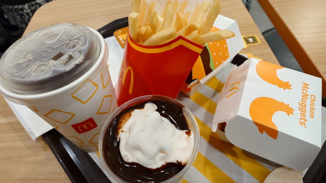 A tray of McDonald's food including fries, a drink, a dessert, and Chicken McNuggets.