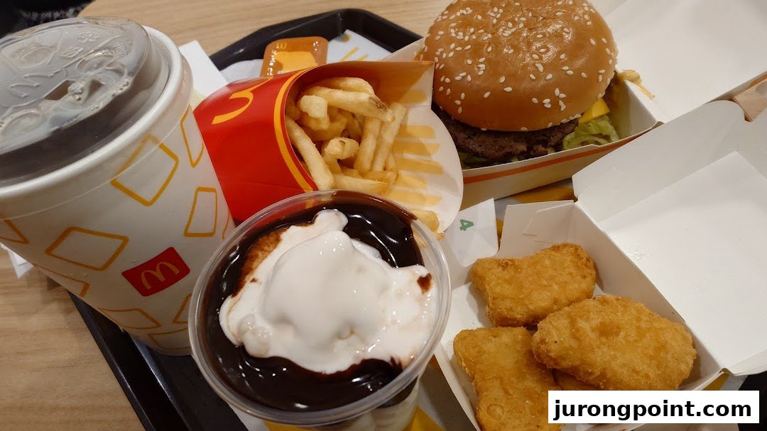 A close-up of a classic McDonald's meal featuring a burger, fries, drink, nuggets, and sundae.