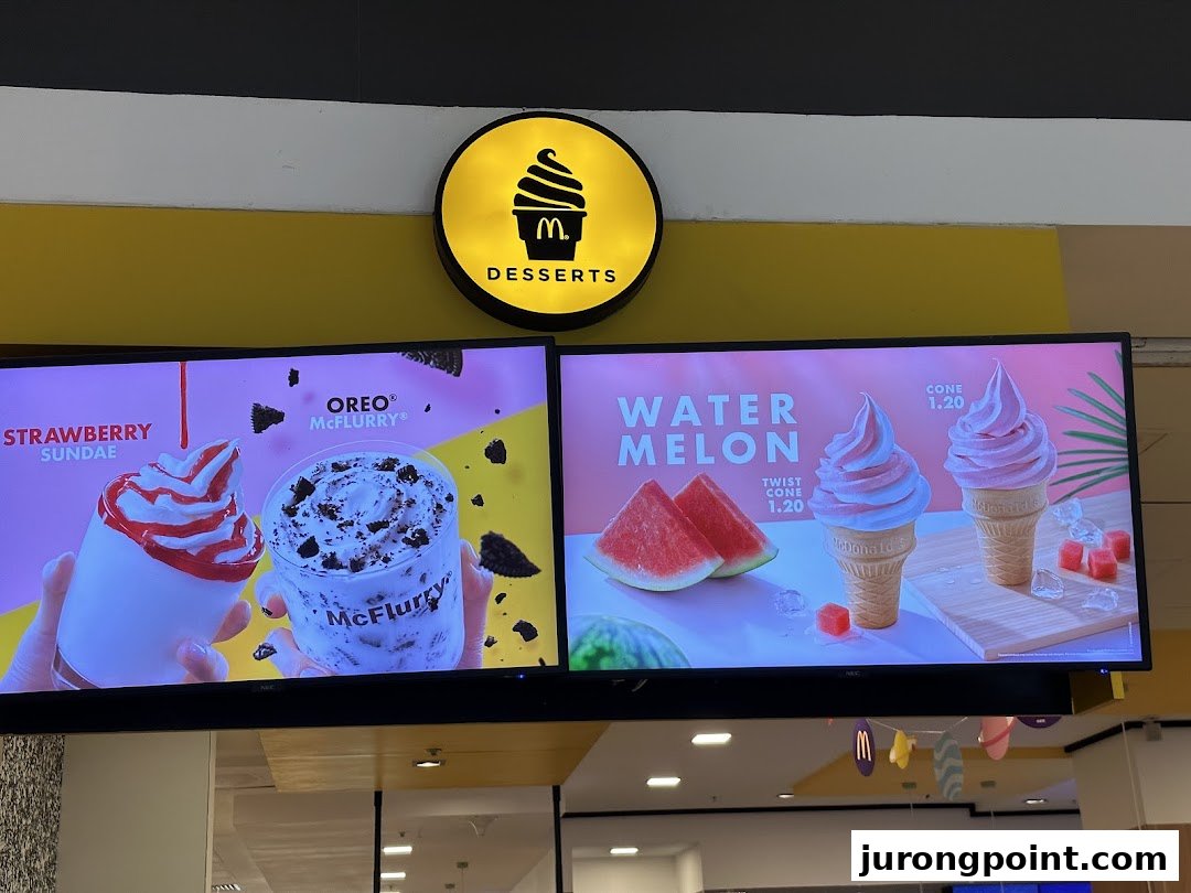 Digital menu boards at McDonald's showcasing a variety of delicious desserts including sundaes, McFlurries, and ice cream cones.