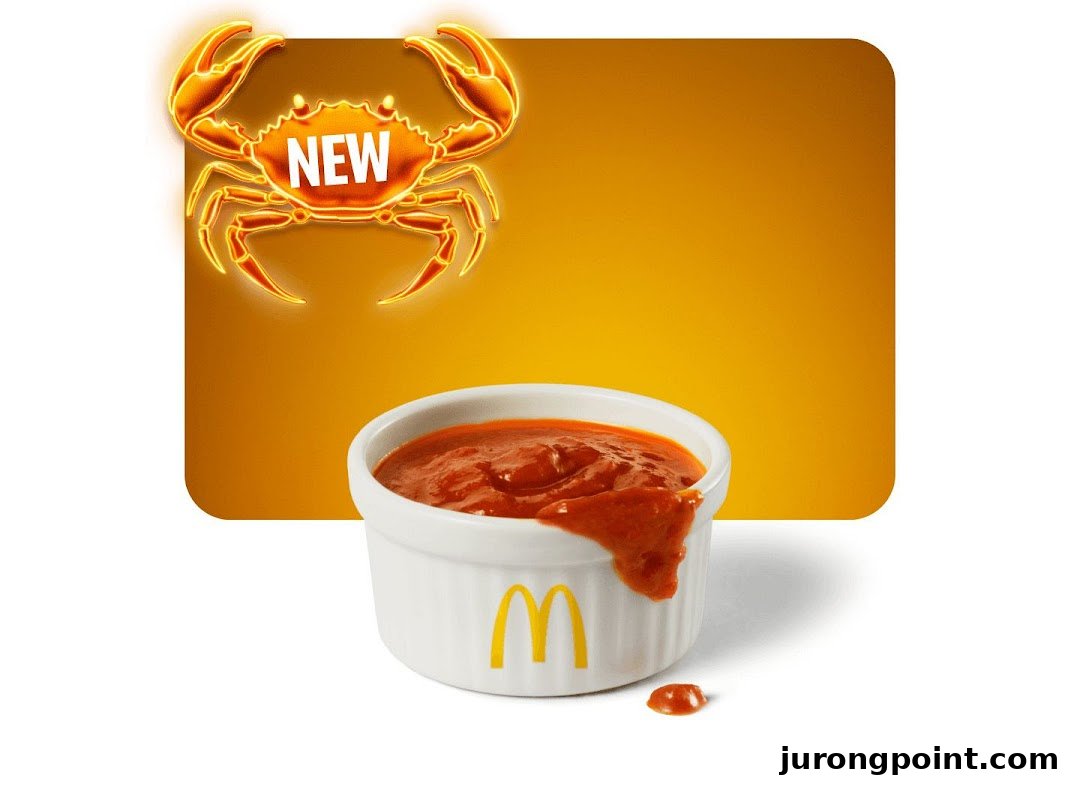 An advertisement featuring a glowing crab graphic with 'NEW' and a McDonald's sauce cup.