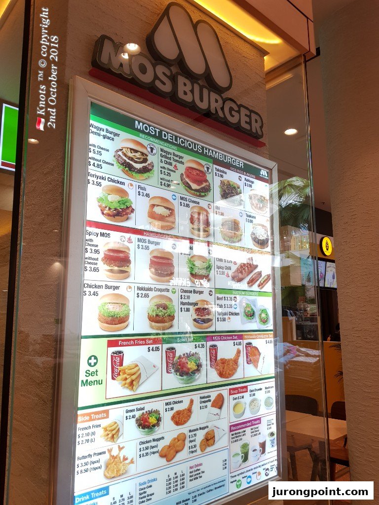 A brightly lit menu board displaying various burgers, sides, and drinks at MOS Burger.