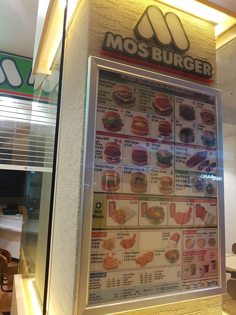 A brightly lit menu board for MOS Burger, showcasing a variety of burgers, sides, and drinks.