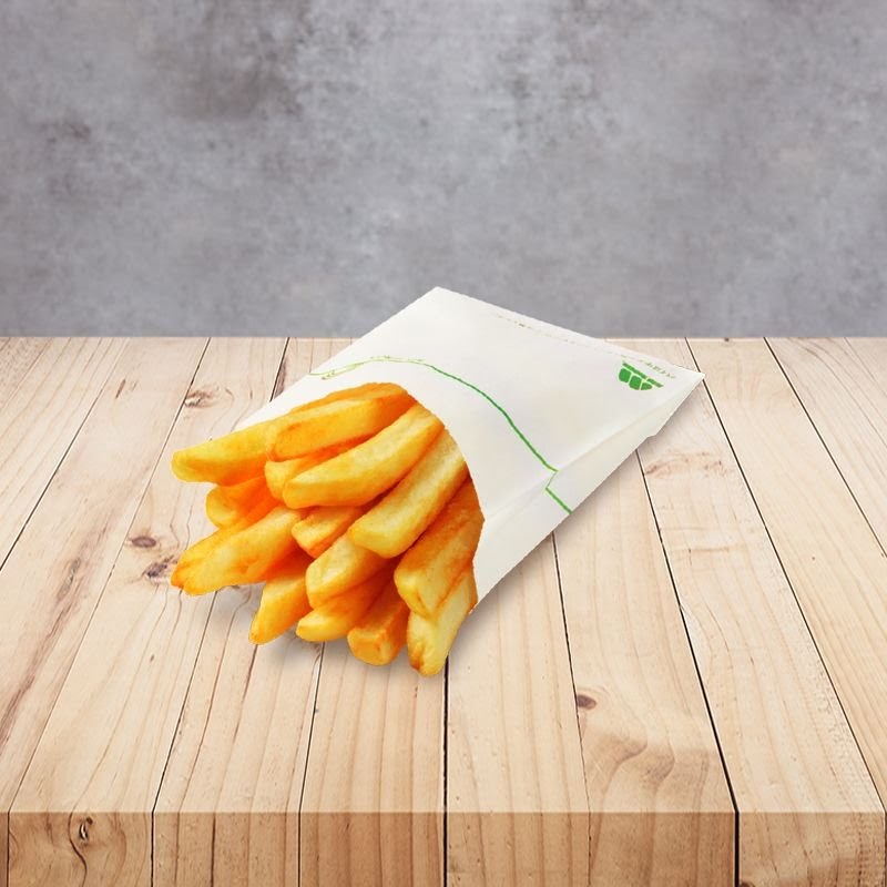 A paper bag filled with golden french fries rests on a light wooden surface.