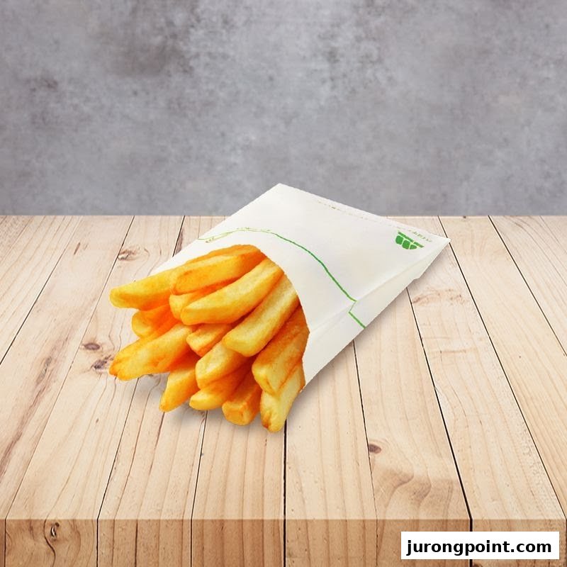 A paper bag filled with golden french fries rests on a light wooden surface.
