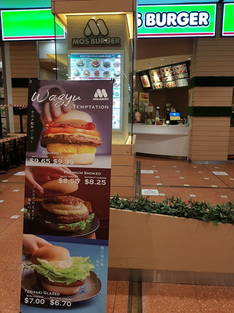 The inviting storefront of MOS Burger, featuring a promotional banner for their gourmet Wagyu and other specialty burgers.