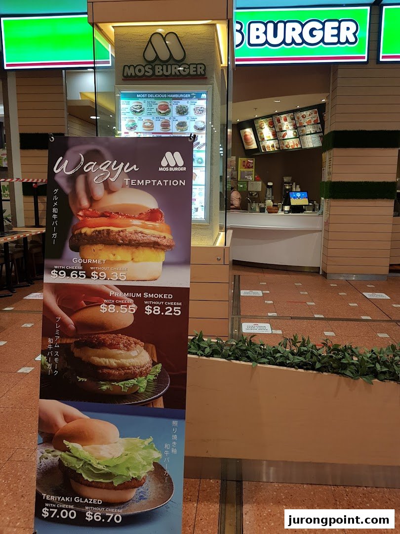 The inviting storefront of MOS Burger, featuring a promotional banner for their gourmet Wagyu and other specialty burgers.