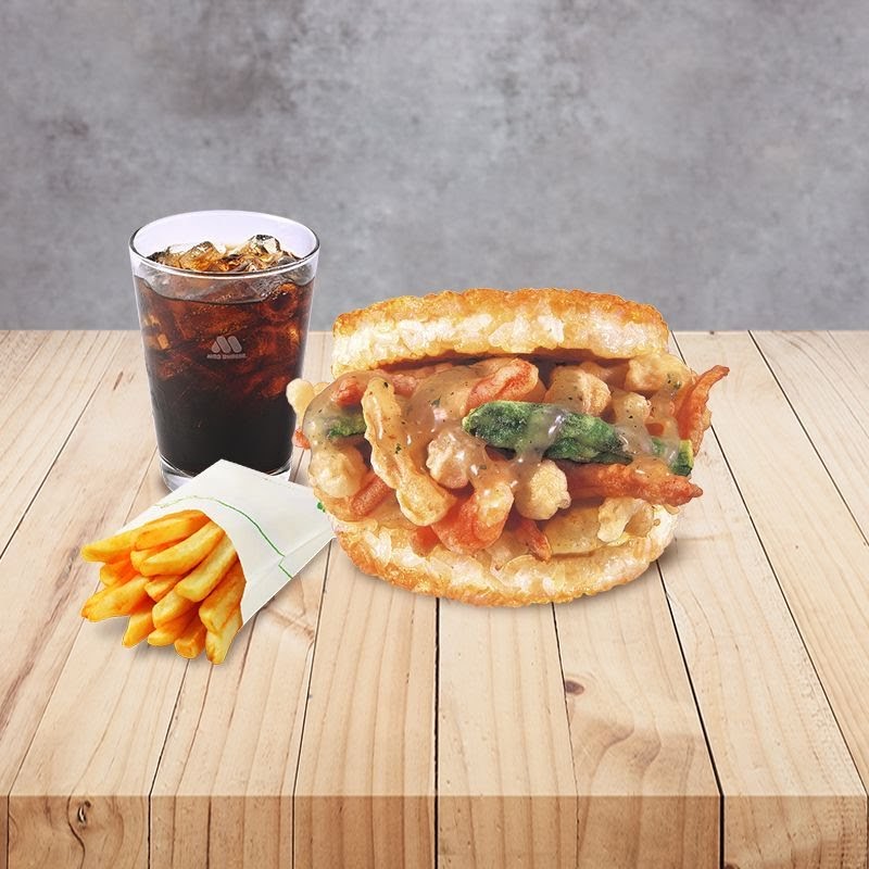 A delicious MOS Burger meal featuring a rice burger, fries, and a refreshing drink on a wooden table.