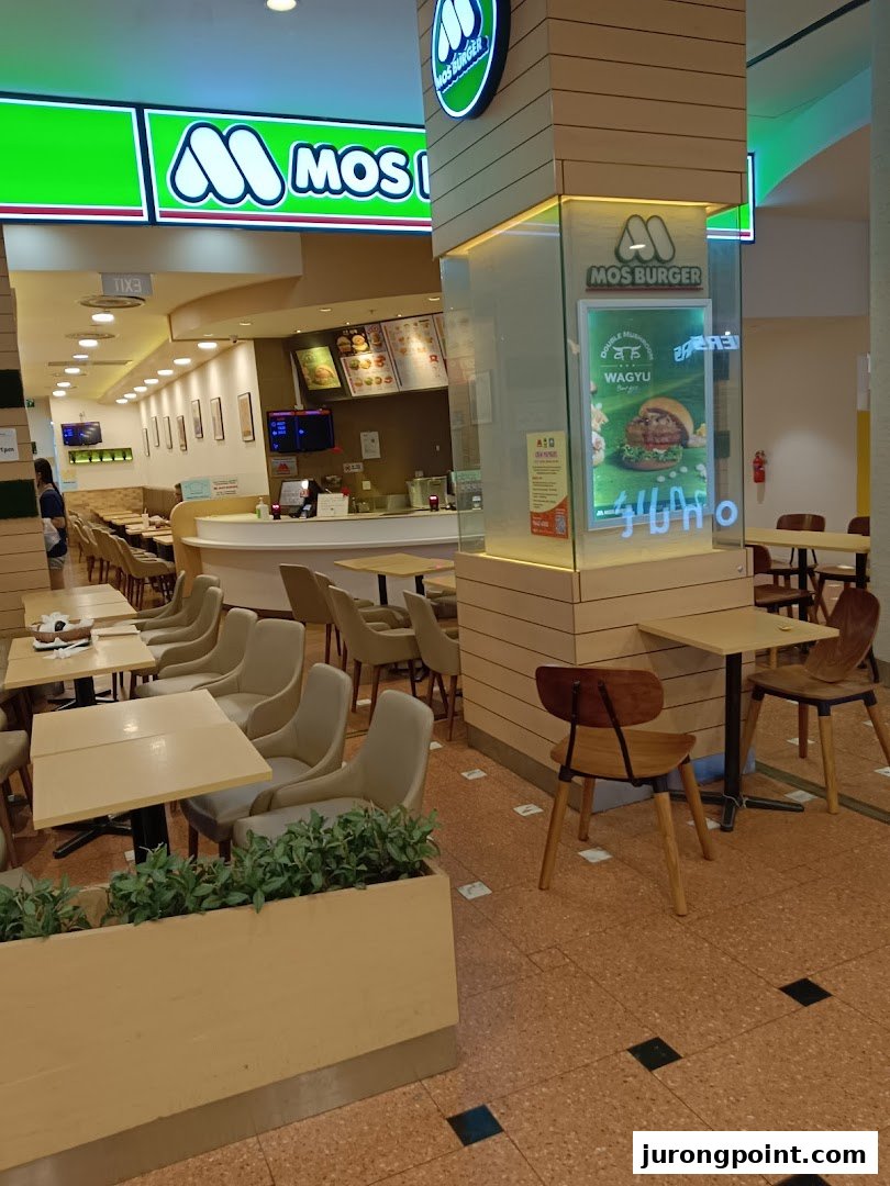 An inviting interior view of MOS Burger, showcasing comfortable seating, a service counter, and brand signage.