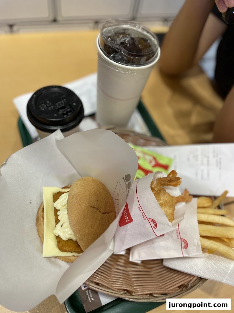 A MOS Burger meal with a fish burger, fried shrimp, fries, and drinks on a tray.