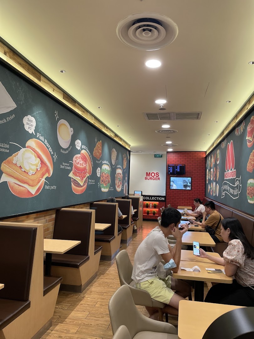 A view of the MOS Burger dining area with customers and illustrated menu walls.