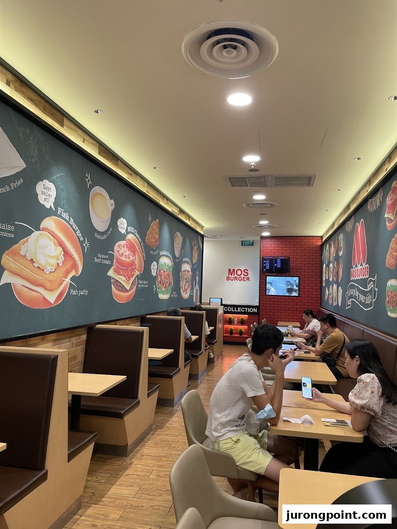 A view of the MOS Burger dining area with customers and illustrated menu walls.