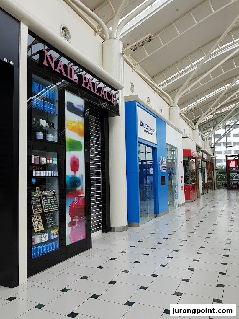 Exterior view of Nail Palace shop front with a display cabinet and closed shutters in a mall corridor.