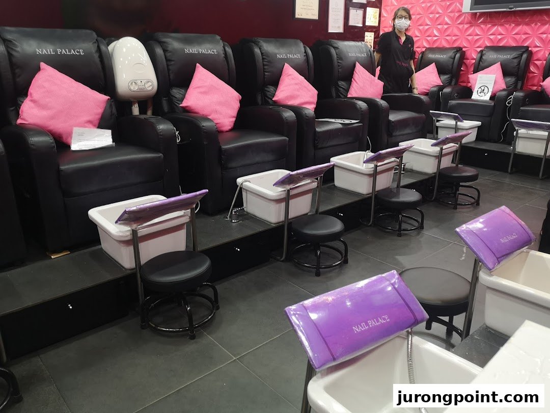 Interior view of Nail Palace showcasing comfortable pedicure stations and a staff member.