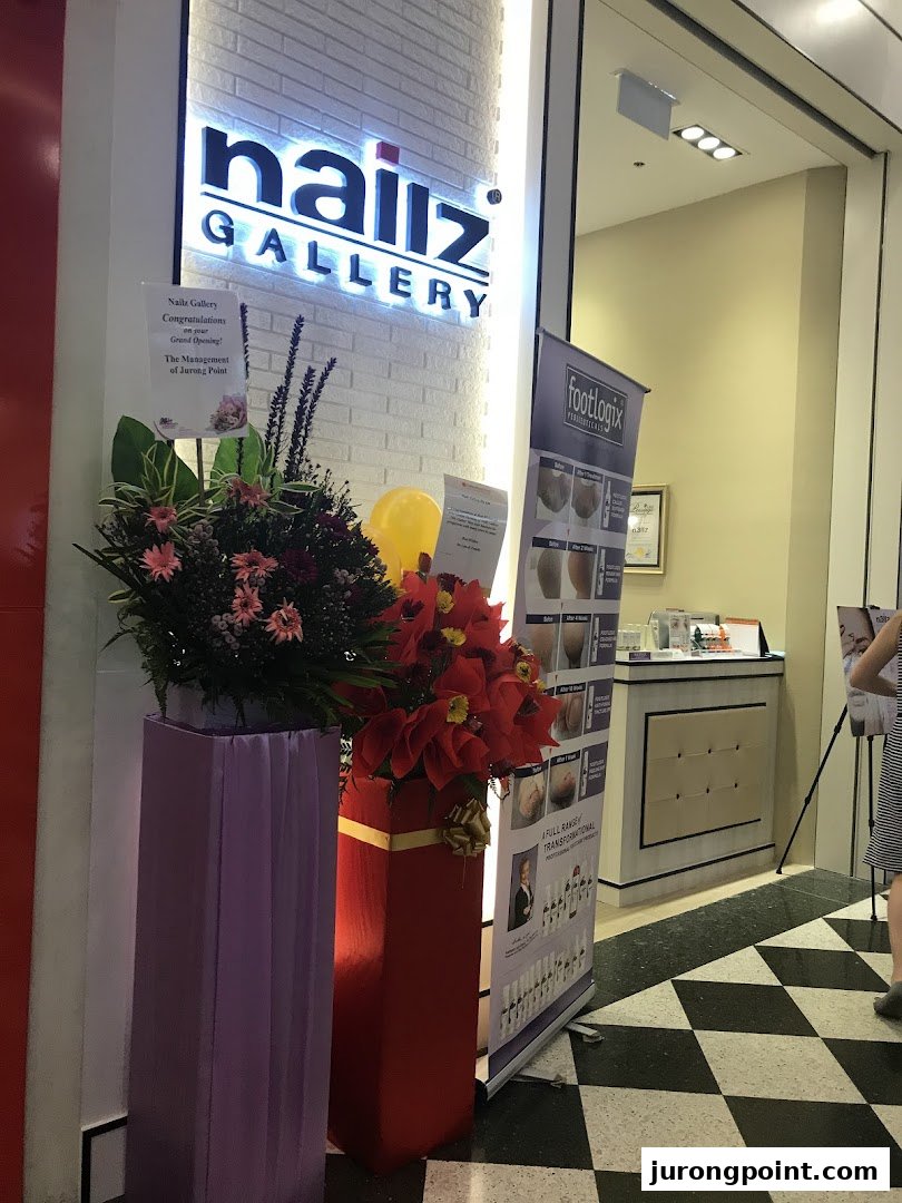 The shop front of Nailz Gallery, adorned with grand opening flowers and a Footlogix banner.