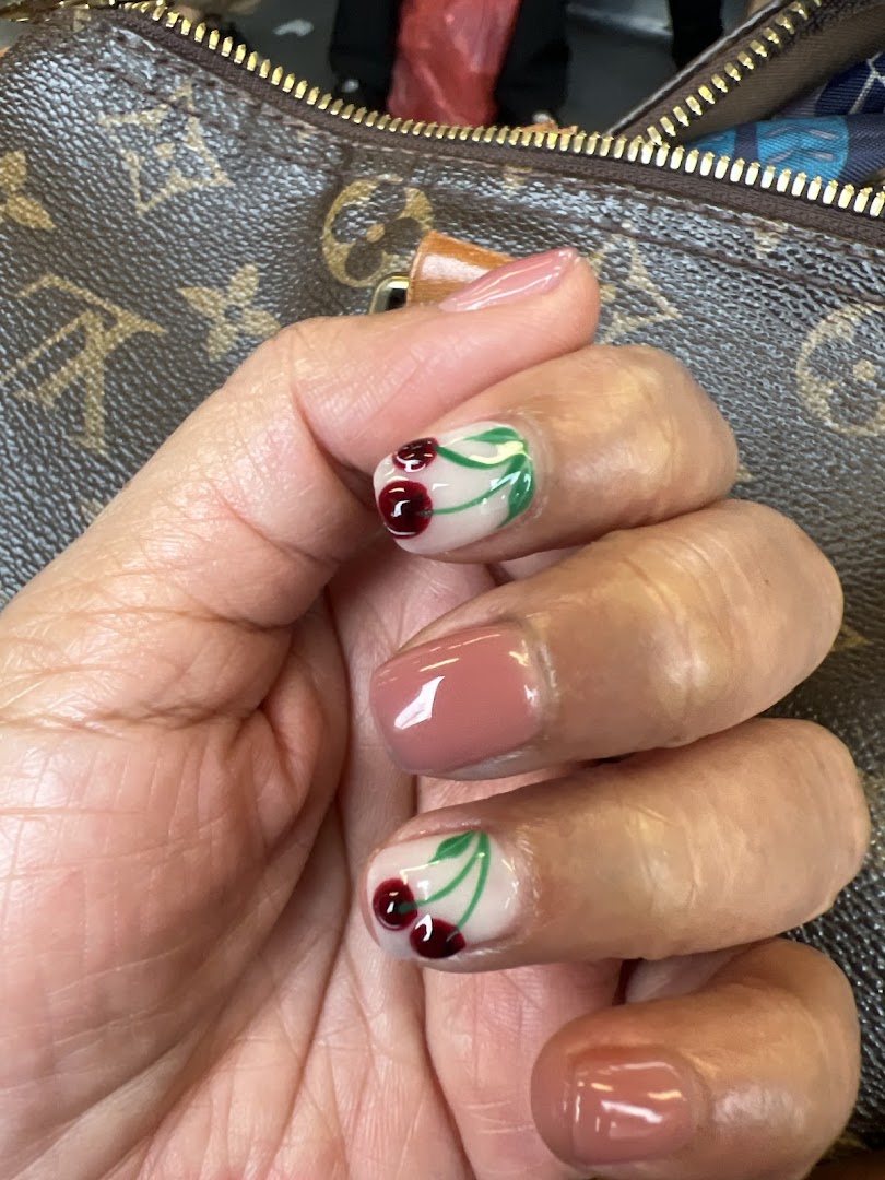 Close-up of a hand showcasing freshly manicured nails with cherry and solid pink designs.