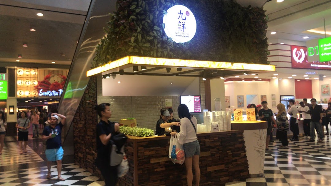 The Nine Fresh Desserts Taiwan kiosk in a bustling shopping mall, serving customers refreshing Taiwanese desserts.