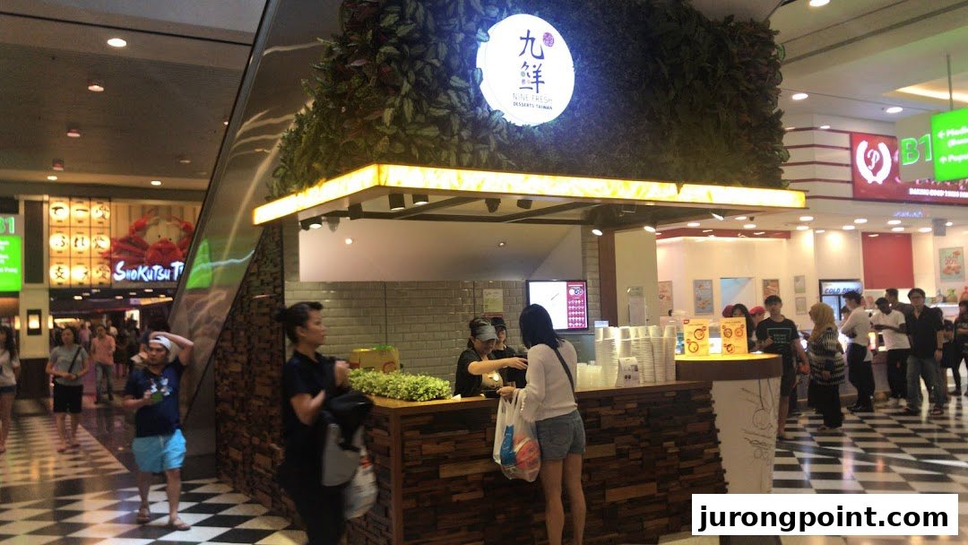 The Nine Fresh Desserts Taiwan kiosk in a bustling shopping mall, serving customers refreshing Taiwanese desserts.