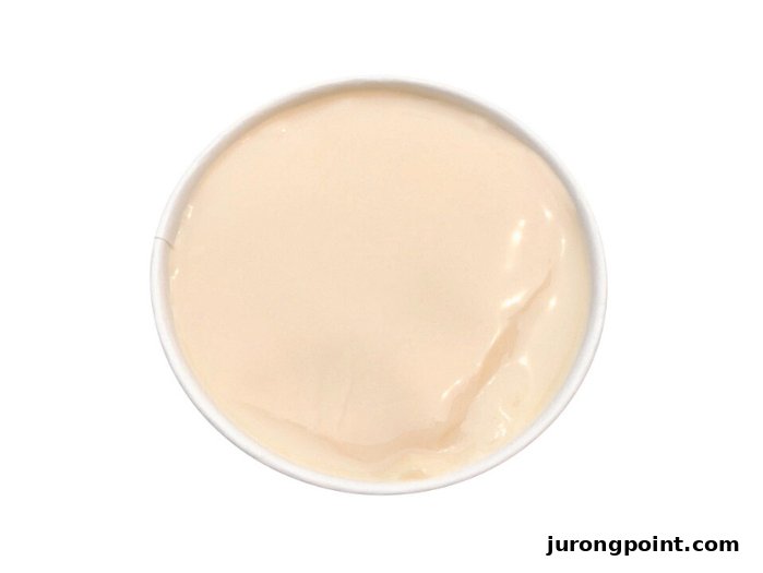 A top-down view of a smooth, light-colored dessert in a white bowl, likely a pudding or panna cotta.
