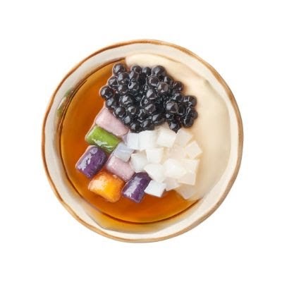 An overhead shot of a colorful Taiwanese dessert bowl with taro balls, pearls, and grass jelly.