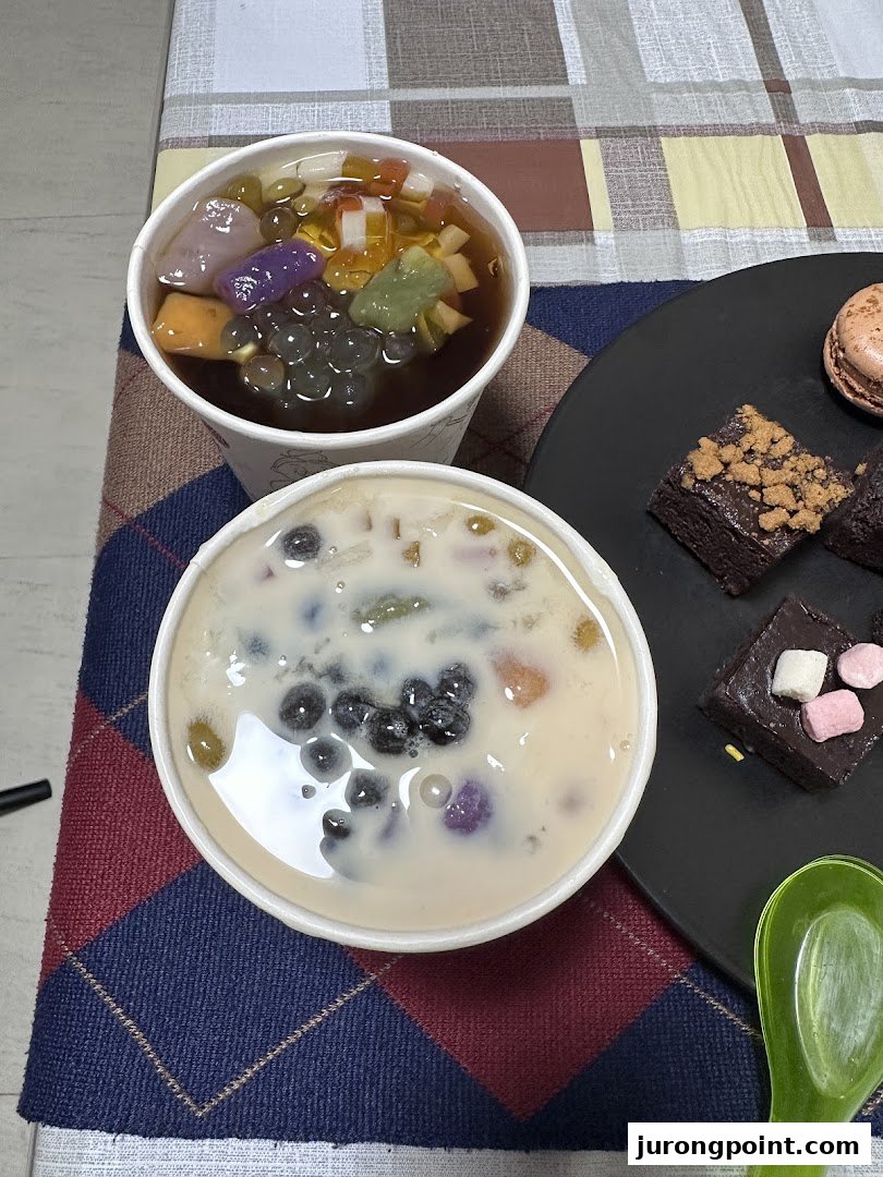 Two refreshing Taiwanese desserts with various toppings and a plate of delightful pastries.