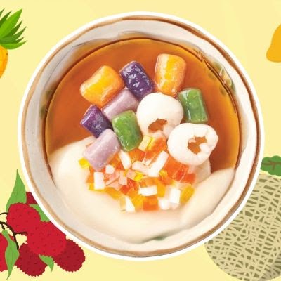 A vibrant bowl of Taiwanese dessert featuring colorful taro balls, lychee, and fruit jellies.