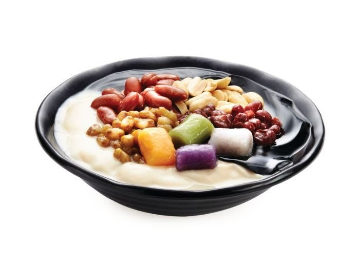 A vibrant bowl of Taiwanese dessert featuring taro balls, beans, and peanuts on a white background.