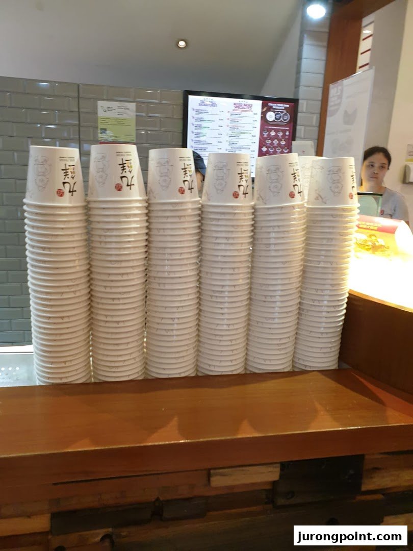 Stacks of branded disposable cups on a wooden counter at Nine Fresh Desserts Taiwan.