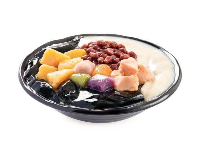 A vibrant bowl of Taiwanese dessert featuring grass jelly, taro balls, sweet potato, and red beans.