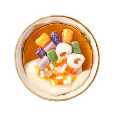 A vibrant bowl of Taiwanese dessert featuring colorful taro balls, lychee, and fruit jelly.