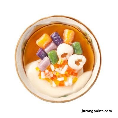 A vibrant bowl of Taiwanese dessert featuring colorful taro balls, lychee, and fruit jelly.