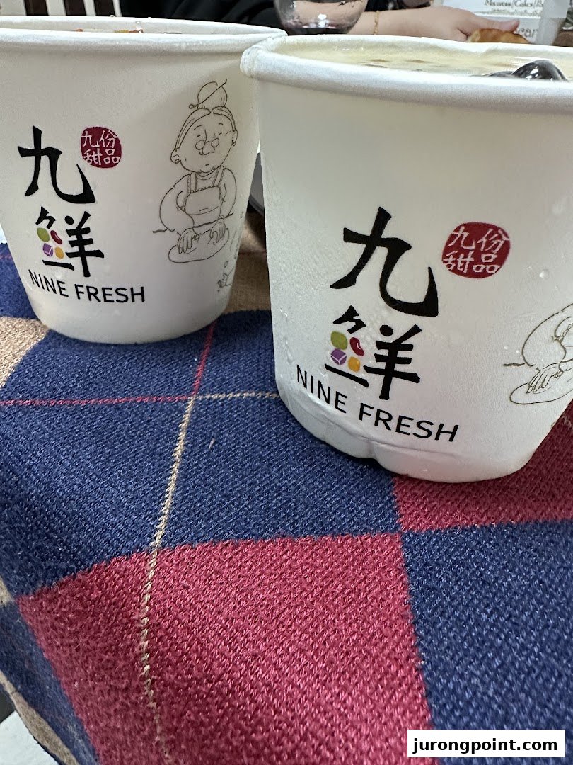 Two Nine Fresh dessert cups with condensation, resting on a plaid surface.