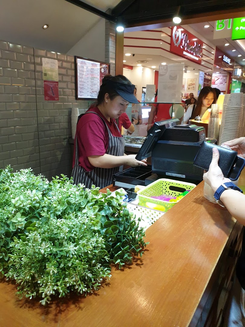 A staff member at Nine Fresh Desserts Taiwan serves a customer at the counter.