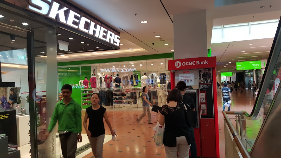 An OCBC ATM machine conveniently located within a bustling shopping mall, near a Skechers store.