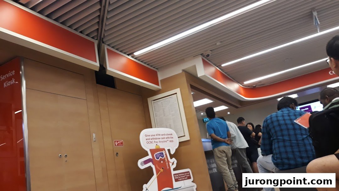 Interior view of OCBC Bank at Jurong Point, showing customers and a service kiosk.
