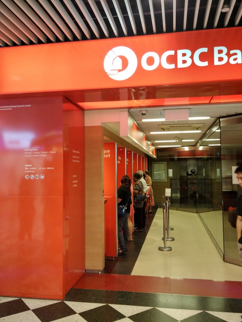 The bright orange entrance of OCBC Bank at Jurong Point, with customers inside.