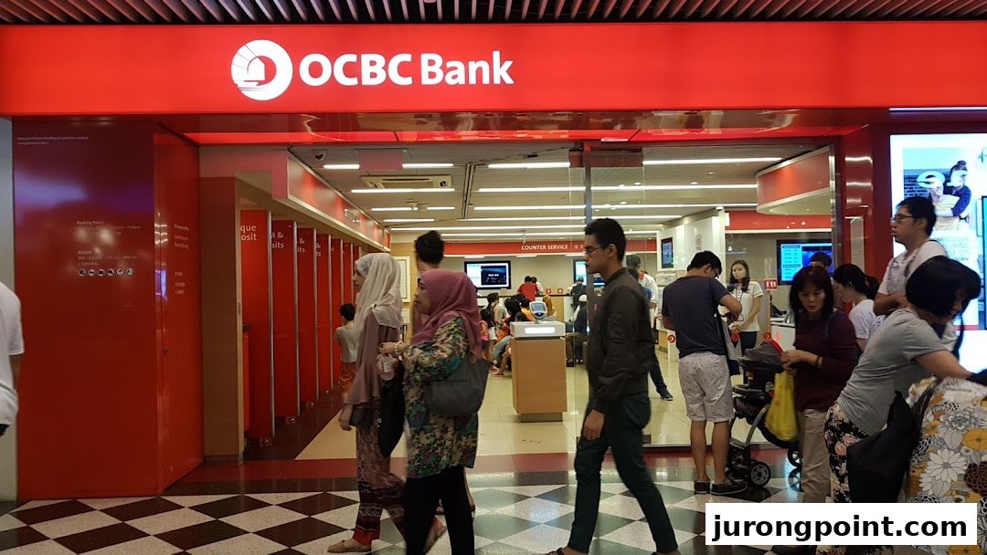 The vibrant red facade of OCBC Bank at Jurong Point, with customers entering and exiting.