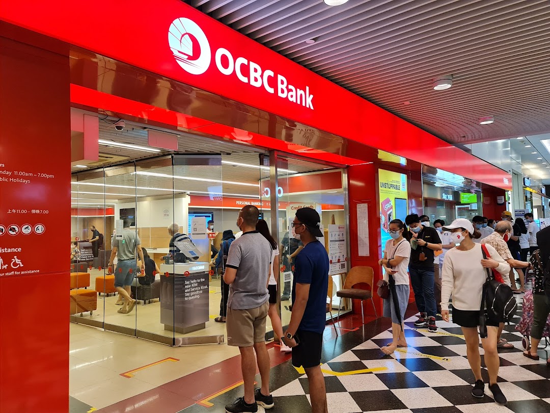 OCBC Bank branch entrance with customers queuing, showcasing banking services.