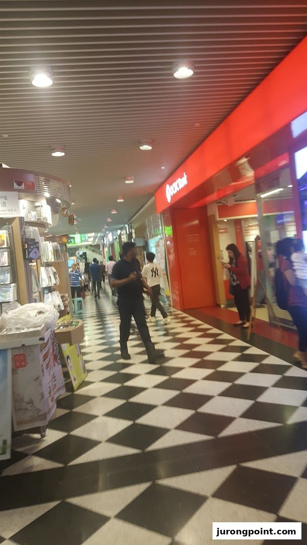 The OCBC Bank branch entrance at Jurong Point, featuring its distinctive red signage and a checkered floor.