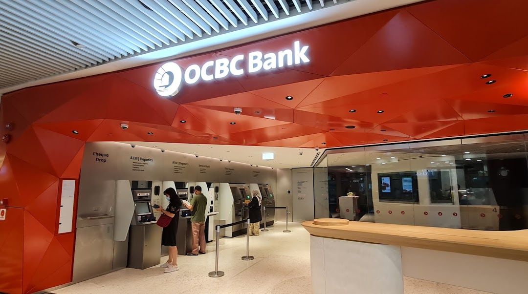 The OCBC Bank branch entrance at Jurong Point, featuring ATMs and customers using banking services.
