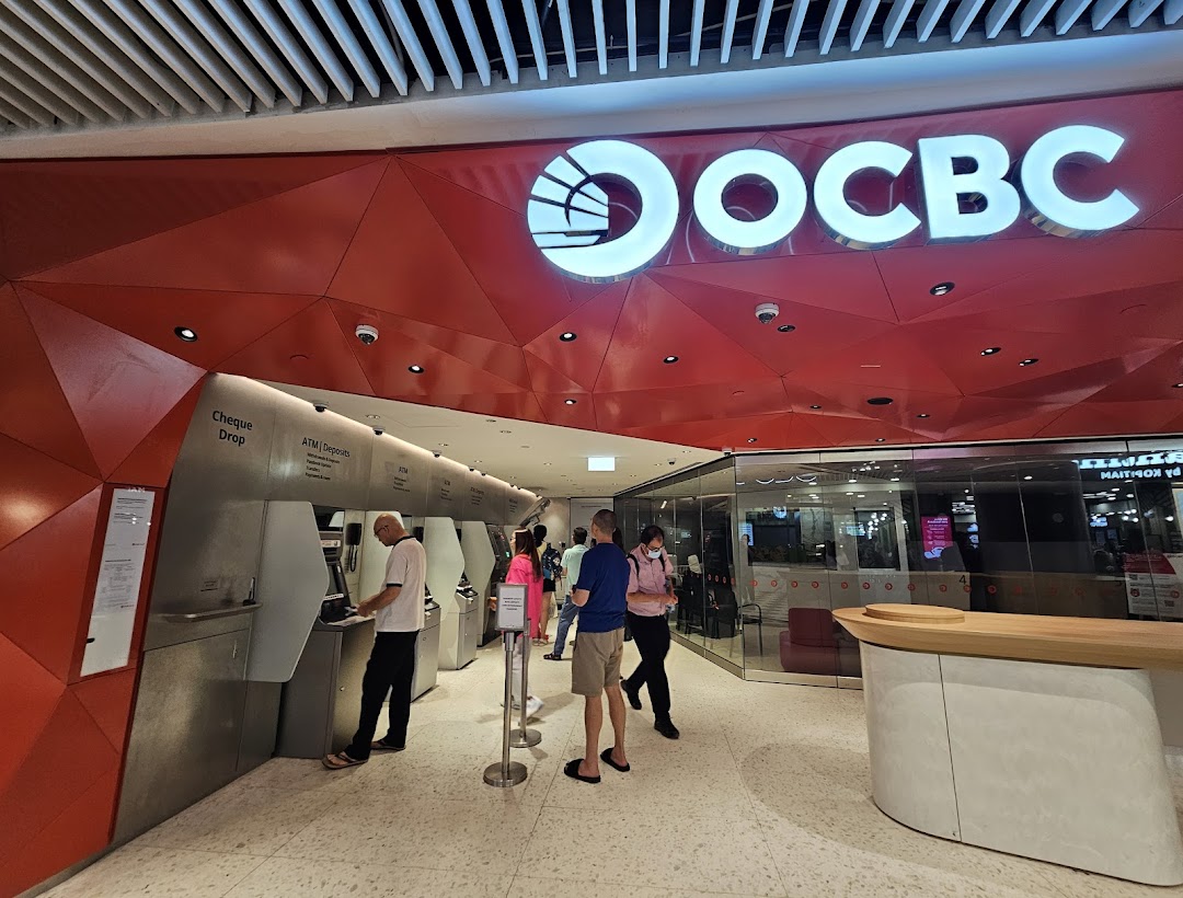Customers use ATMs and access services at the modern OCBC Bank branch entrance.