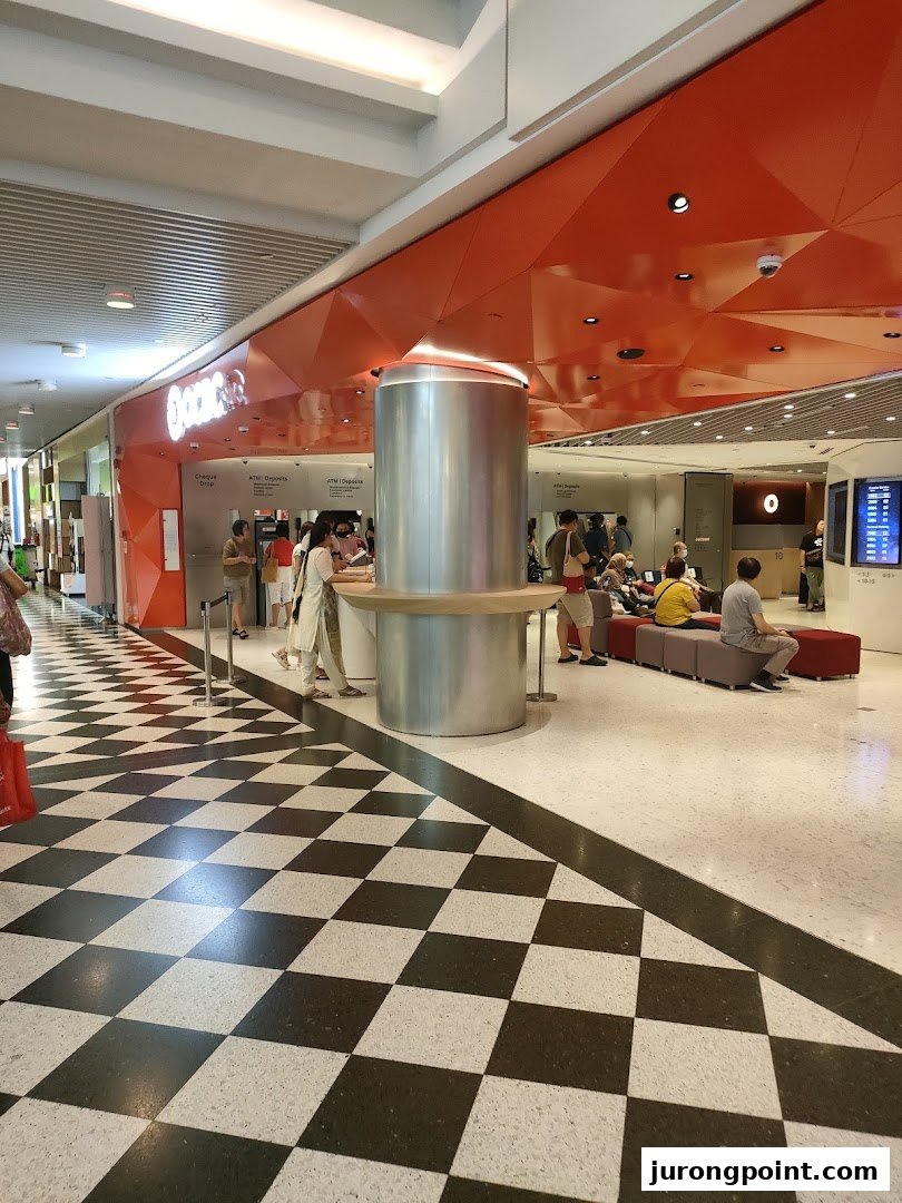 The OCBC Bank branch at Jurong Point features a distinctive orange facade and a checkered floor entrance.