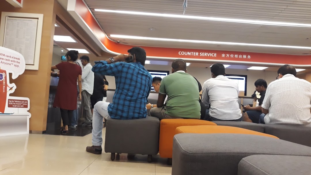 Customers are seen waiting and being served at the OCBC Bank counter service area.
