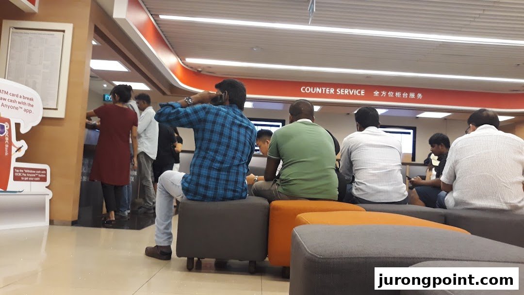 Customers are seen waiting and being served at the OCBC Bank counter service area.