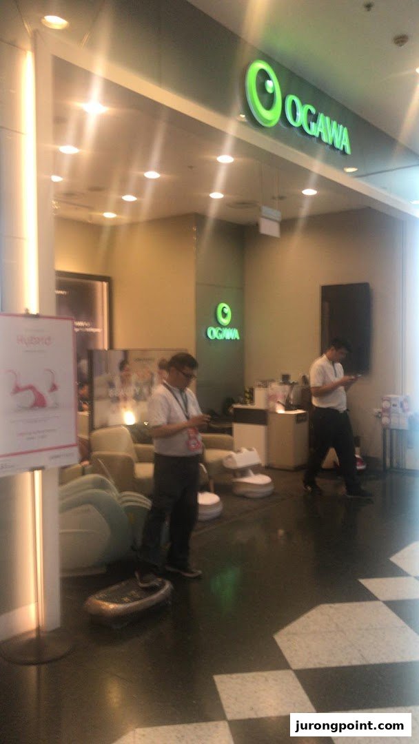 The inviting entrance of OGAWA, a wellness store, showcasing massage products and staff inside.