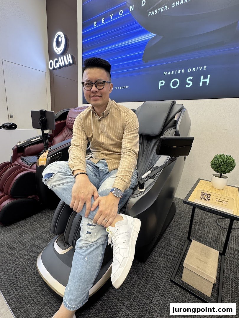 A man comfortably seated on a premium massage chair inside the OGAWA store, showcasing the product.