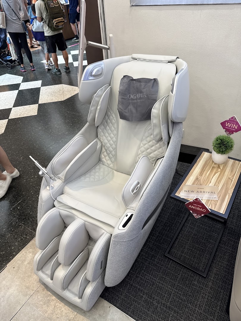 A modern white massage chair displayed in an OGAWA retail space, inviting relaxation.