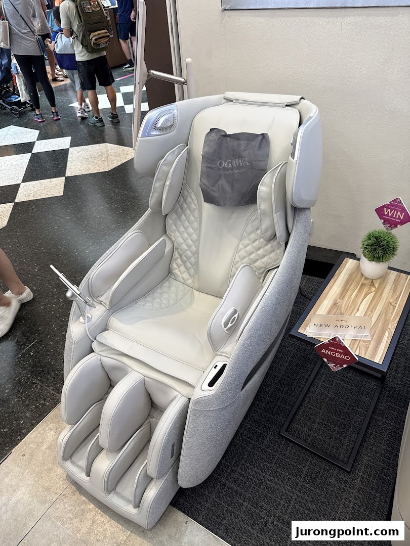 A modern white massage chair displayed in an OGAWA retail space, inviting relaxation.