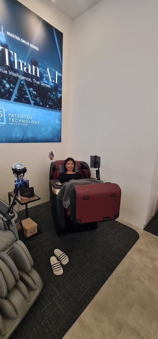 A woman relaxes in a luxurious massage chair at Ogawa, showcasing advanced wellness technology.