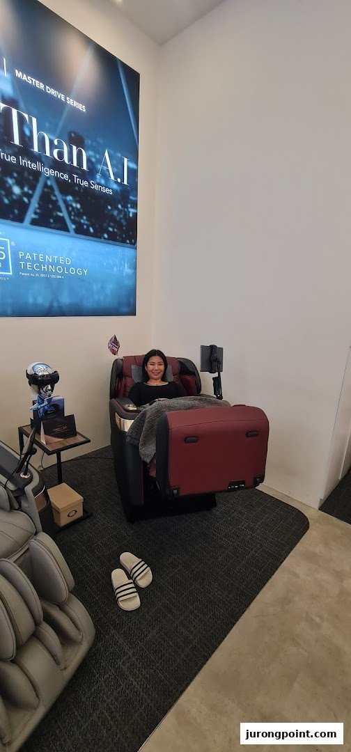 A woman relaxes in a luxurious massage chair at Ogawa, showcasing advanced wellness technology.