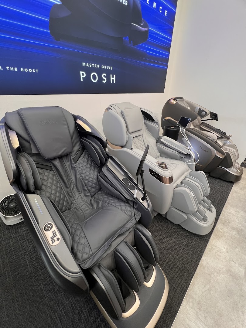 Three modern OGAWA massage chairs displayed in a retail showroom, with a 'MASTER DRIVE POSH' banner.